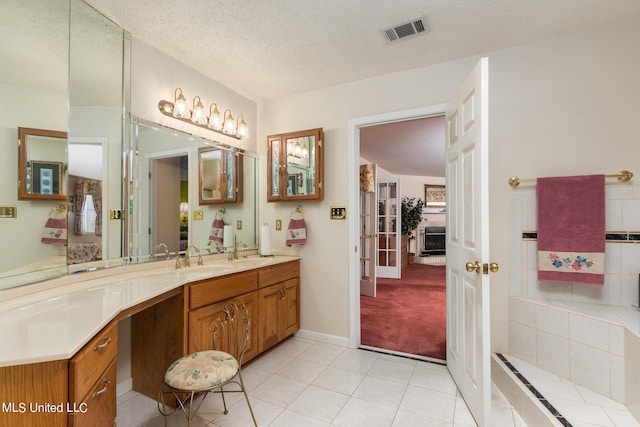 bathroom featuring vanity, a textured ceiling, radiator heating unit, and tile patterned flooring