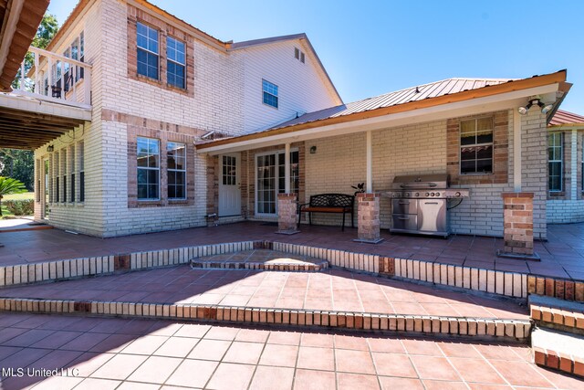 rear view of property with a patio and a balcony