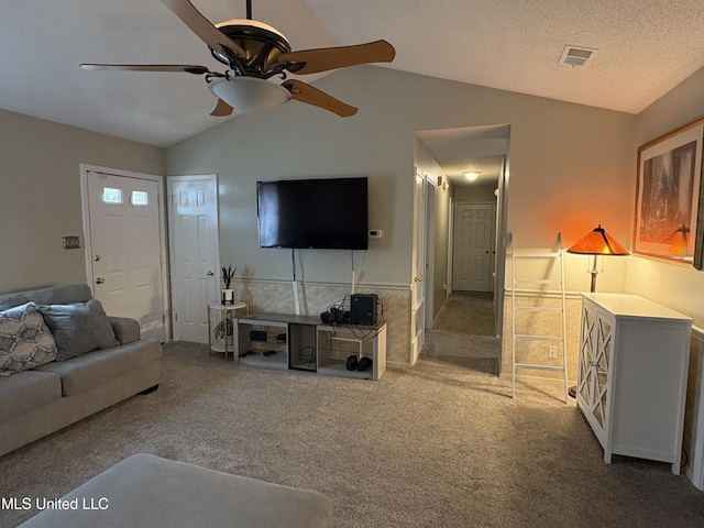 carpeted living room featuring a textured ceiling, ceiling fan, and vaulted ceiling