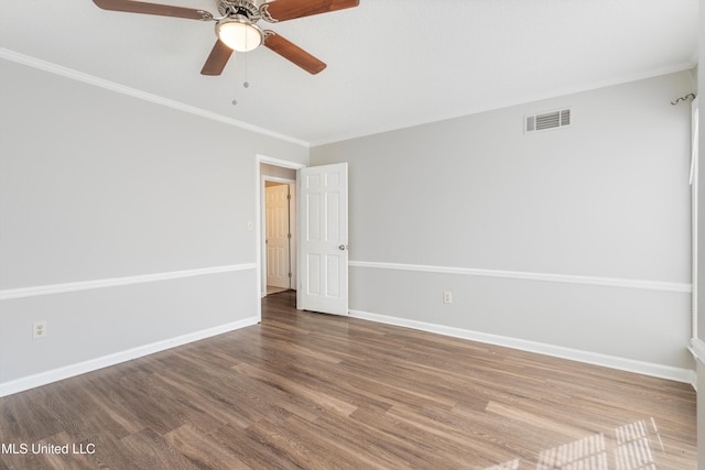 empty room with crown molding, ceiling fan, and wood-type flooring