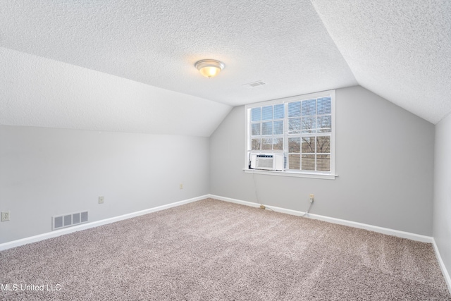 bonus room featuring lofted ceiling, cooling unit, a textured ceiling, and carpet flooring