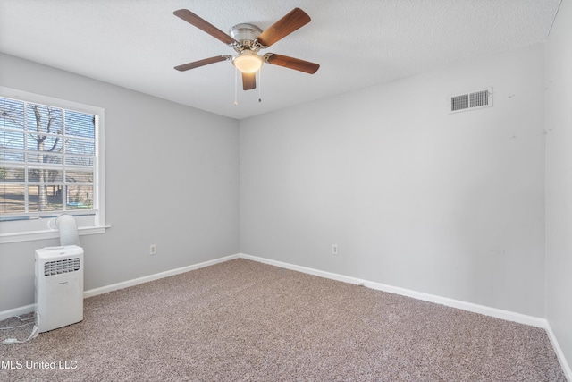 unfurnished room featuring ceiling fan, a textured ceiling, and carpet