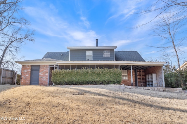 rear view of property with a lawn