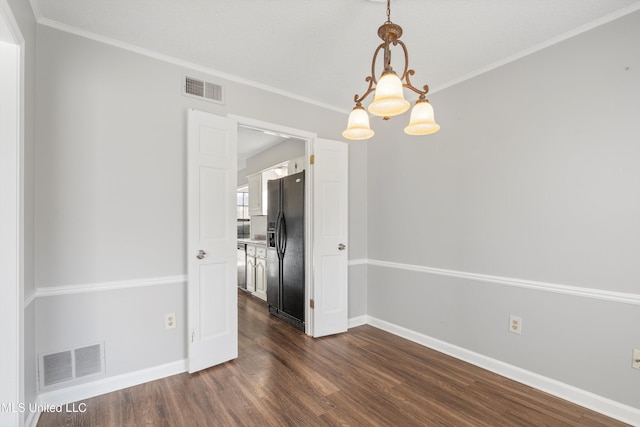 empty room with dark wood-type flooring, ornamental molding, and a chandelier