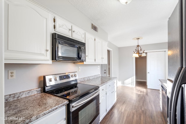 kitchen featuring decorative light fixtures, white cabinets, hardwood / wood-style flooring, black appliances, and a textured ceiling