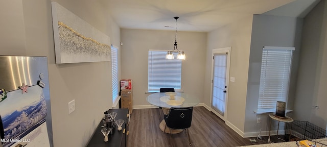 dining space with baseboards and wood finished floors