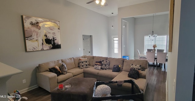 living area featuring dark wood finished floors, a towering ceiling, baseboards, and ceiling fan