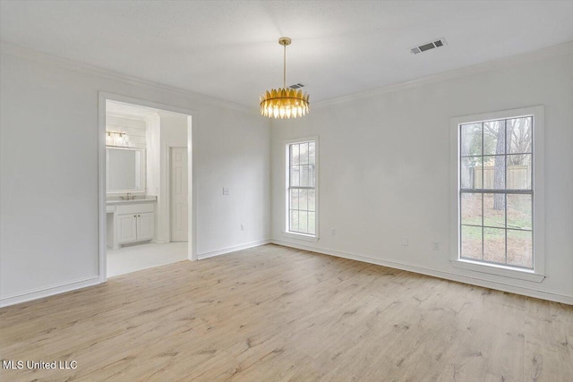 spare room with sink, plenty of natural light, ornamental molding, and light wood-type flooring