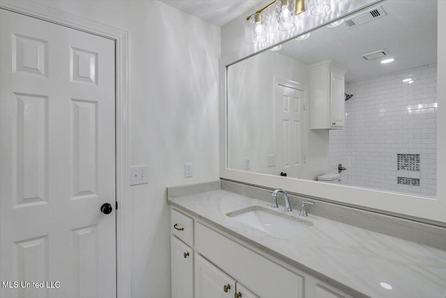 bathroom with vanity and tiled shower