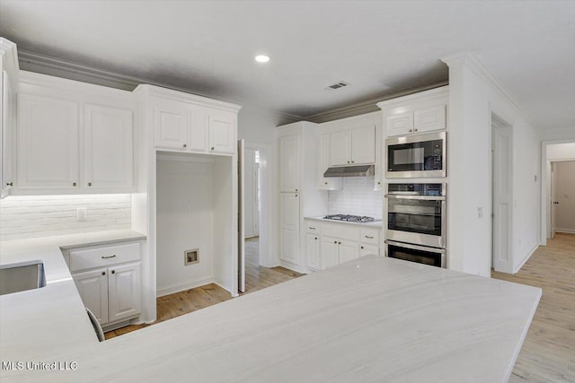 kitchen with crown molding, light hardwood / wood-style floors, white cabinets, and appliances with stainless steel finishes