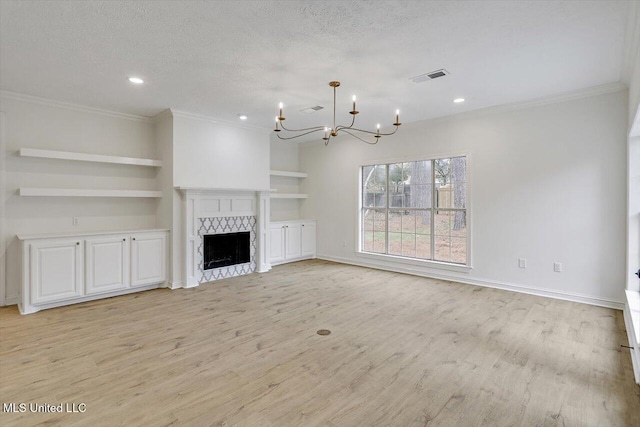 unfurnished living room with an inviting chandelier, built in features, ornamental molding, a textured ceiling, and light wood-type flooring