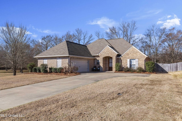 view of front of property with a garage, fence, concrete driveway, and brick siding