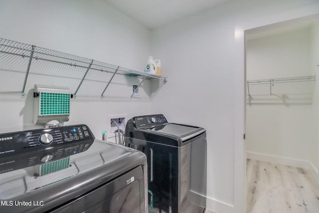 washroom with washer and dryer and light hardwood / wood-style flooring