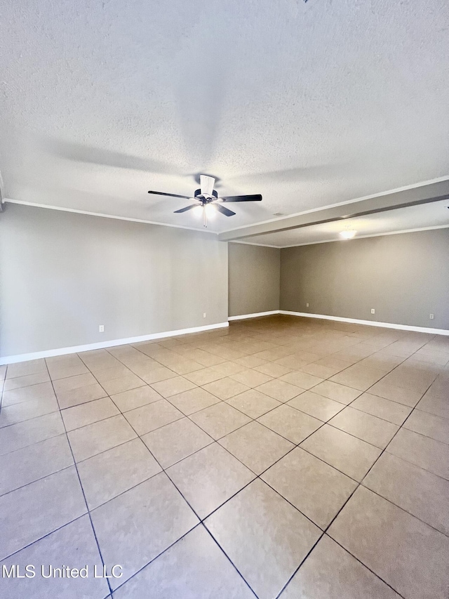 spare room featuring ceiling fan, light tile patterned floors, and a textured ceiling