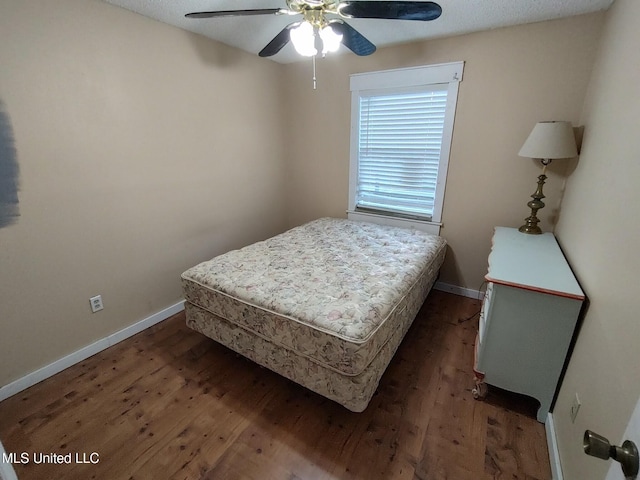 bedroom featuring a textured ceiling, ceiling fan, and dark wood-type flooring