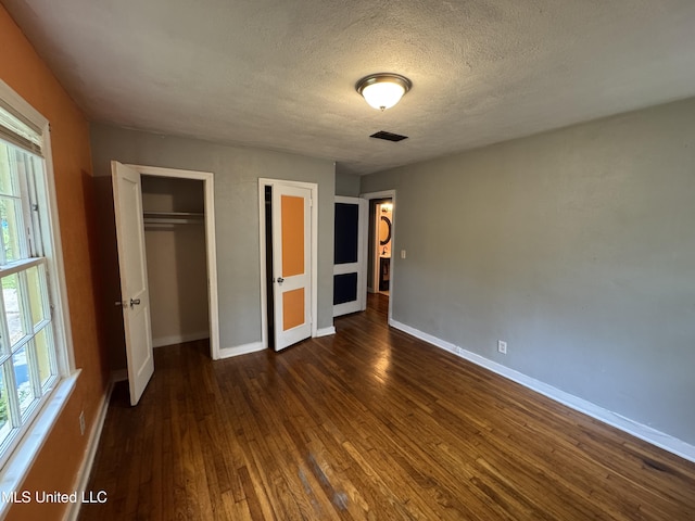 3258 Meadow Ln, Jackson, MS 39212 - unfurnished bedroom with dark wood-style flooring, a textured ceiling, and a closet