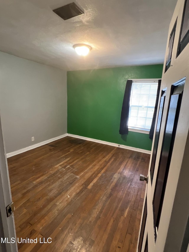 3258 Meadow Ln, Jackson, MS 39212 - spare room featuring dark wood-style floors and a textured ceiling