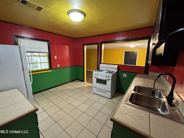 3258 Meadow Ln, Jackson, MS 39212 - kitchen with white appliances, a textured ceiling, and light tile patterned flooring