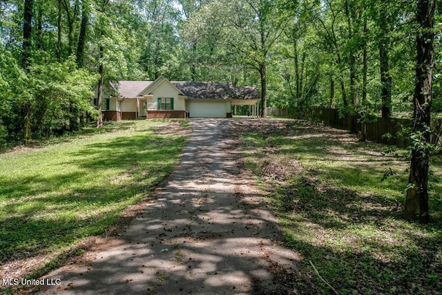 7488 Hickory Estates Dr, Walls, MS 38680 - view of front of house featuring a forest view, driveway, fence, a front lawn, and an attached garage