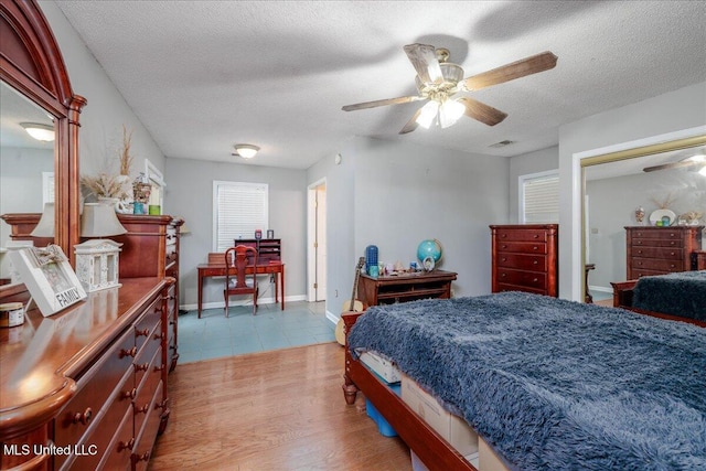 7488 Hickory Estates Dr, Walls, MS 38680 - bedroom featuring visible vents, light wood-style floors, baseboards, ceiling fan, and a textured ceiling