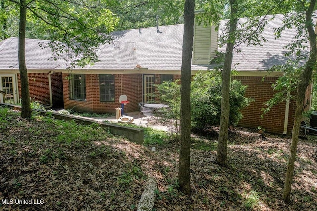 7488 Hickory Estates Dr, Walls, MS 38680 - rear view of house featuring brick siding, a shingled roof, a patio area, and a chimney