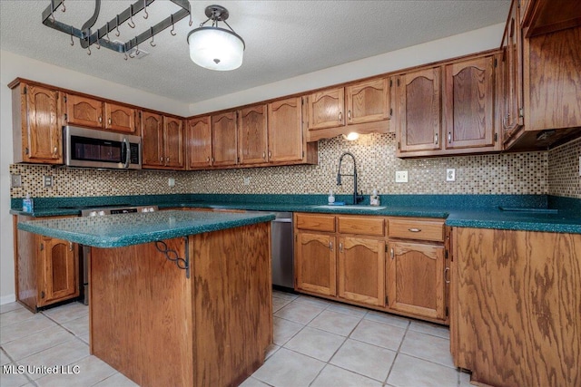 7488 Hickory Estates Dr, Walls, MS 38680 - kitchen with decorative backsplash, brown cabinets, a sink, light tile patterned floors, and stainless steel appliances