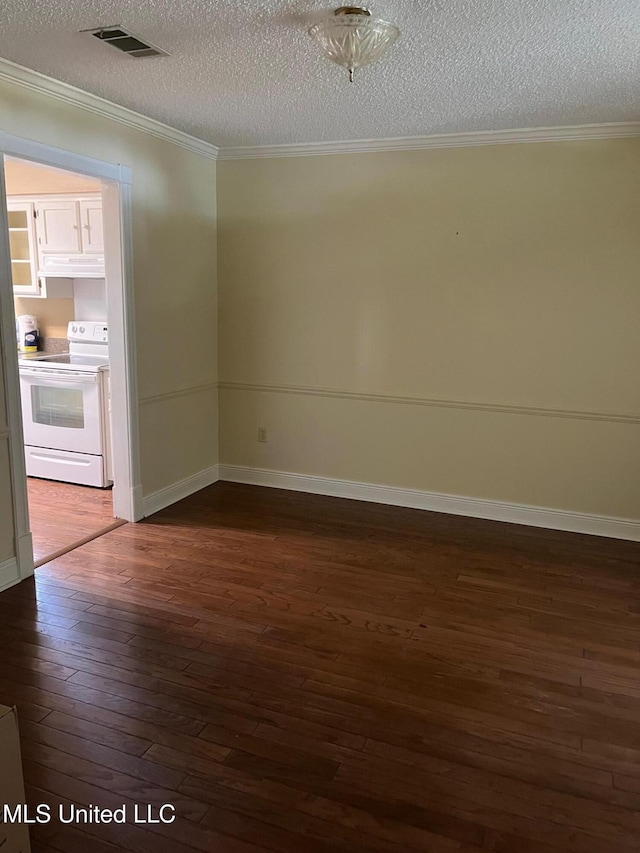 spare room featuring a textured ceiling, visible vents, baseboards, ornamental molding, and dark wood-style floors