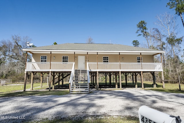 view of front facade with stairs, a porch, and a shingled roof