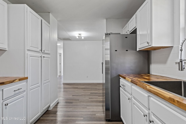 kitchen with butcher block counters, dark wood-style flooring, decorative backsplash, and white cabinets