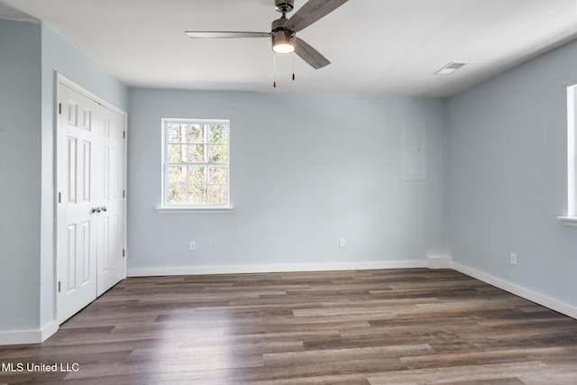 spare room featuring wood finished floors, visible vents, and baseboards