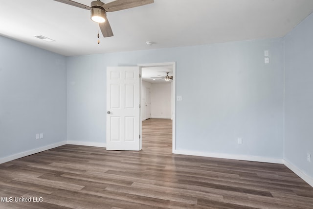 unfurnished room with a ceiling fan, visible vents, baseboards, and wood finished floors