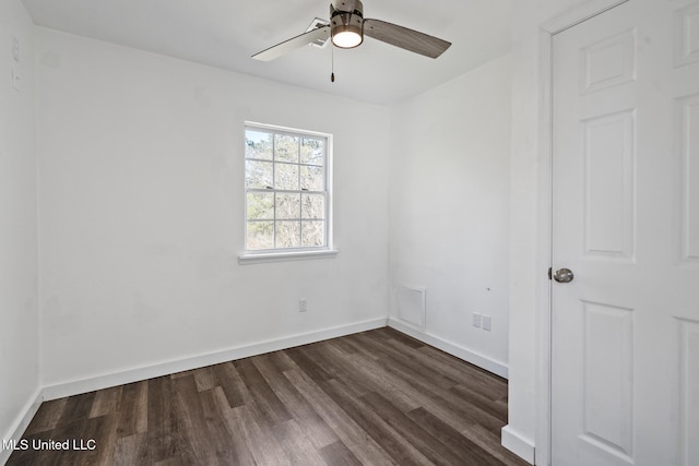 unfurnished room featuring dark wood-style floors, a ceiling fan, and baseboards