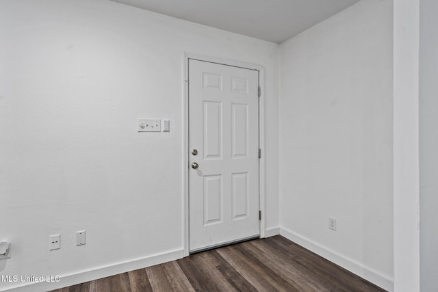 spare room featuring dark wood finished floors and baseboards