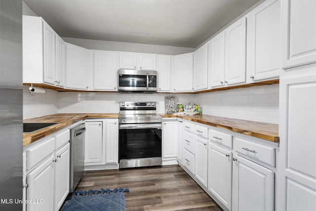 kitchen featuring appliances with stainless steel finishes, wooden counters, and tasteful backsplash