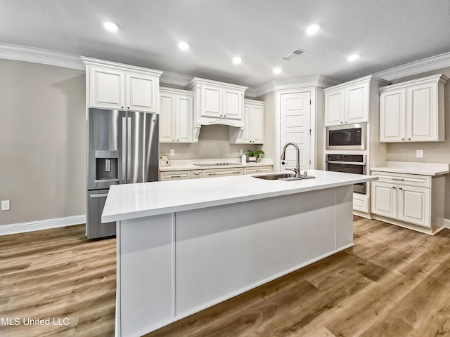16814 W Landon Green Dr, Gulfport, MS 39503 - kitchen with stainless steel appliances, crown molding, light countertops, an island with sink, and wood finished floors