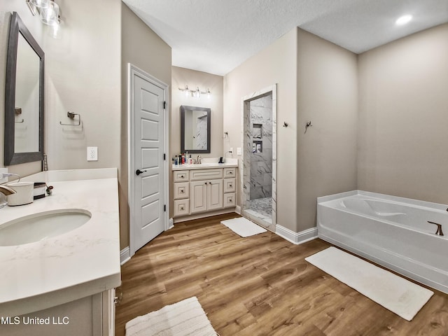 16814 W Landon Green Dr, Gulfport, MS 39503 - bathroom with a garden tub, wood finished floors, a stall shower, and two vanities