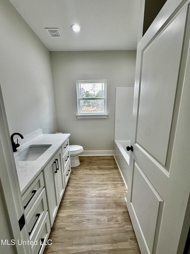 bathroom featuring toilet, hardwood / wood-style floors, and vanity