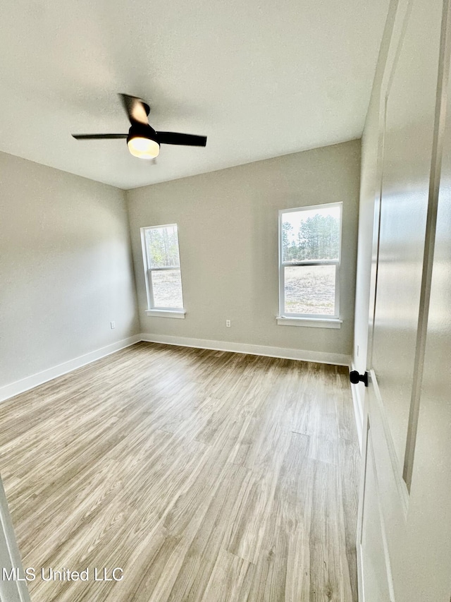 spare room with light wood-type flooring and ceiling fan