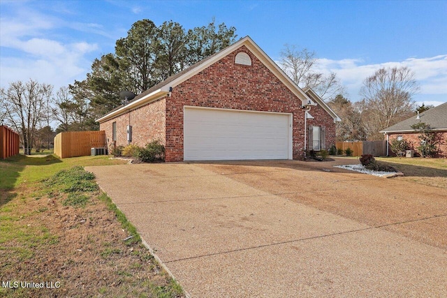 view of front facade featuring a garage, concrete driveway, fence, central AC, and brick siding