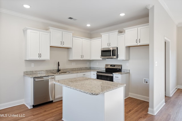 kitchen with a sink, light wood-style flooring, baseboards, and stainless steel appliances