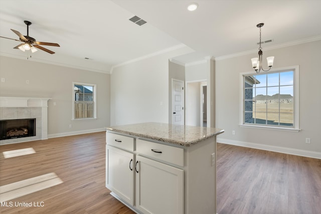kitchen with ornamental molding, visible vents, and plenty of natural light