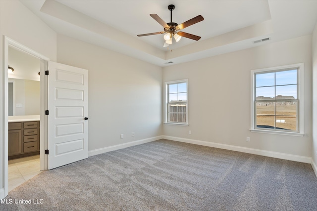 spare room with light carpet, baseboards, a ceiling fan, and visible vents