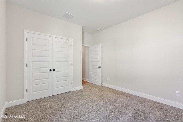 unfurnished bedroom with a closet, carpet flooring, and baseboards