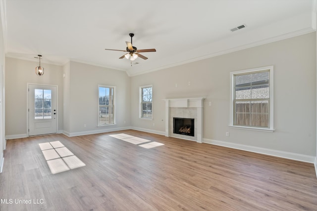 unfurnished living room featuring light wood finished floors, ceiling fan, baseboards, and ornamental molding