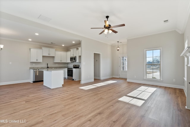 unfurnished living room featuring visible vents, baseboards, crown molding, and ceiling fan