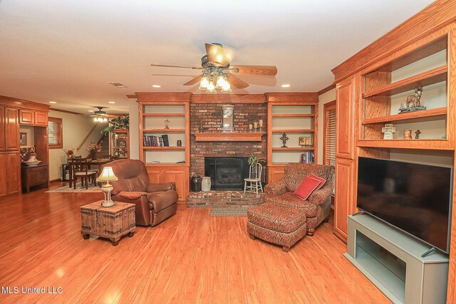 living area with light wood-type flooring, a brick fireplace, ceiling fan, and visible vents