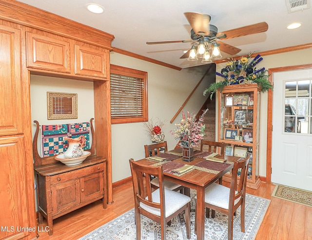 dining area featuring light wood-style floors, visible vents, ornamental molding, and baseboards