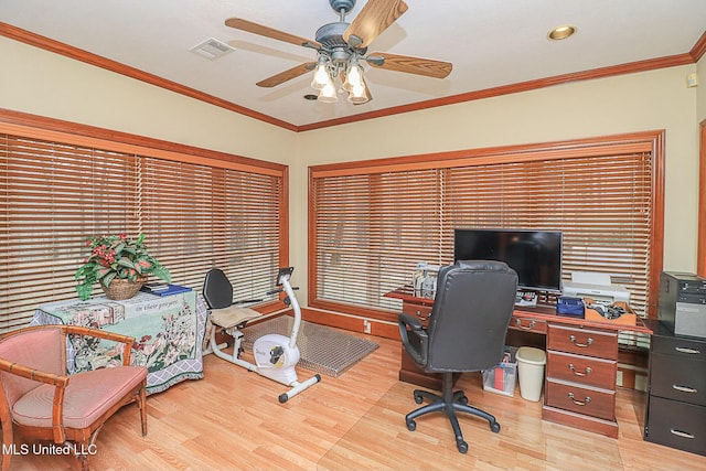 office space with ornamental molding, visible vents, light wood-style flooring, and a ceiling fan