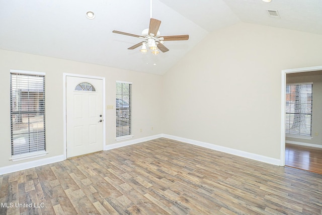 interior space featuring baseboards, visible vents, a ceiling fan, lofted ceiling, and wood finished floors