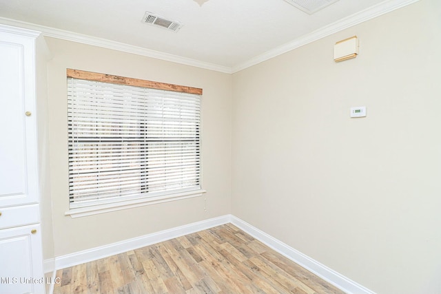 empty room with light wood-style floors, visible vents, baseboards, and crown molding